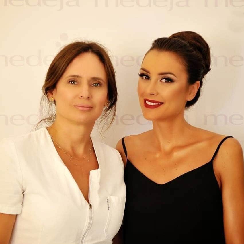 Драгана Мичалович в салон Medeja, пред стената с логото на салона